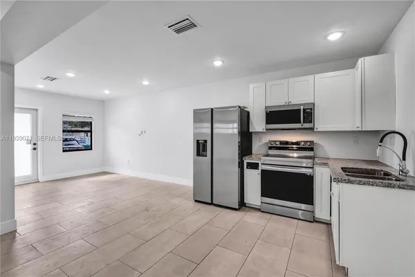a kitchen with stainless steel appliances granite countertop a refrigerator and a stove top oven