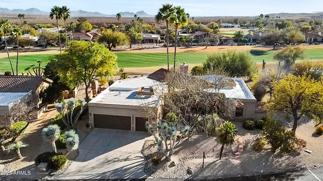 an aerial view of a house with a yard and lake view