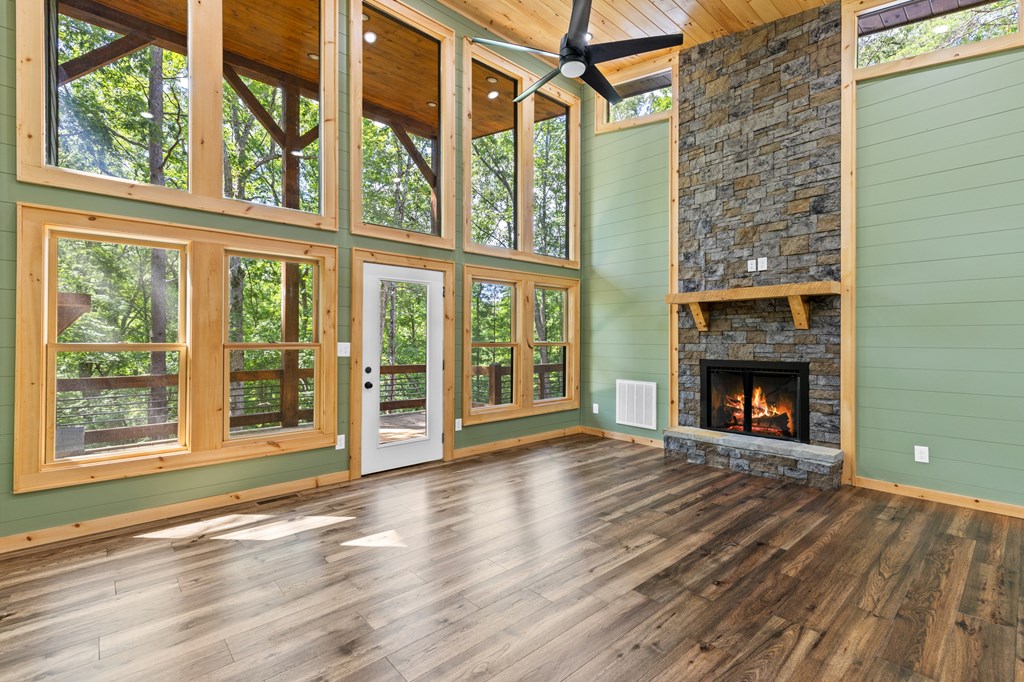 307 Mangum's Trail Blue Ridge, GA 30513 - Photo 16 of 36 a view of an empty room with wooden floor fireplace and a window