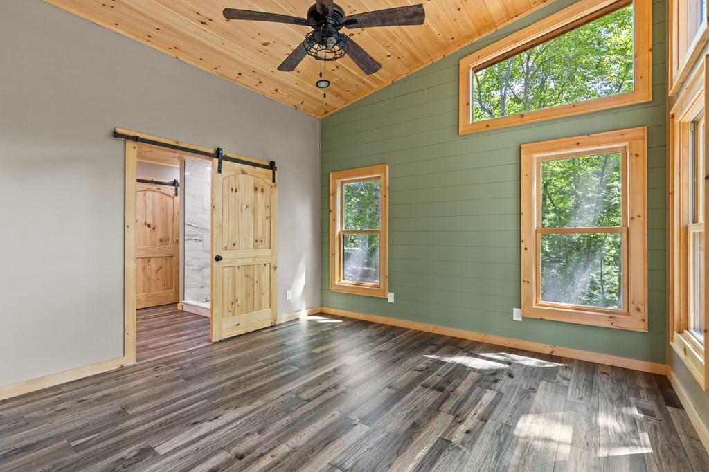 307 Mangum's Trail Blue Ridge, GA 30513 - Photo 21 of 36 an empty room with wooden floor fan and windows