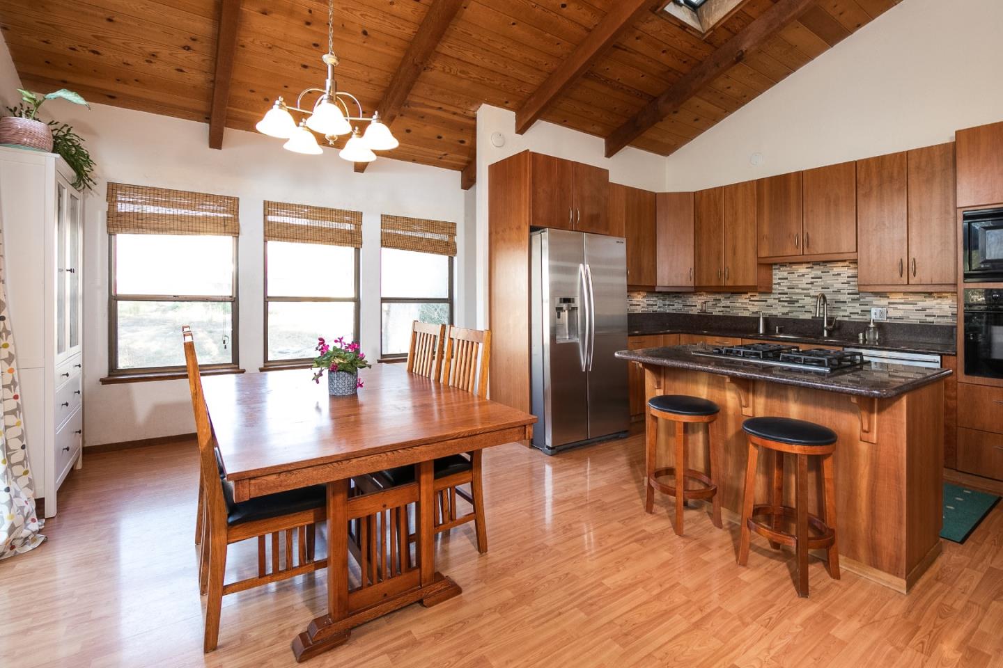 6113 Abbey Road Aptos, CA 95003 - Photo 7 of 20 a kitchen with stainless steel appliances granite countertop a stove a refrigerator a sink a dining table and chairs with wooden floor