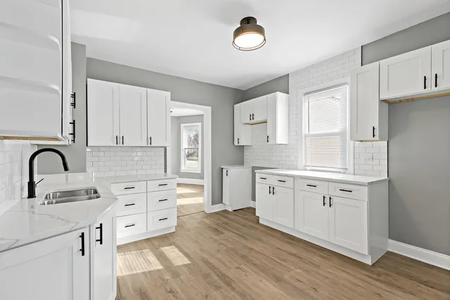 a kitchen with granite countertop white cabinets and appliances