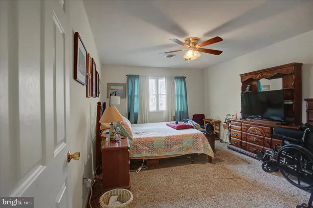 a bedroom with bed and a flat tv screen on dresser