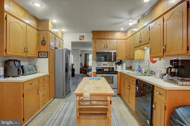 a kitchen with stainless steel appliances a refrigerator sink stove microwave and cabinets
