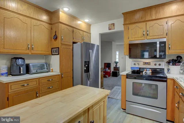 a kitchen with stainless steel appliances a stove microwave and refrigerator