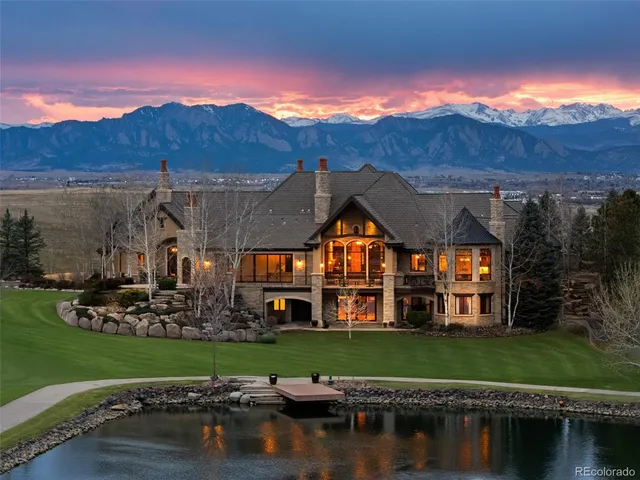 a view of a big house with a big yard and large trees