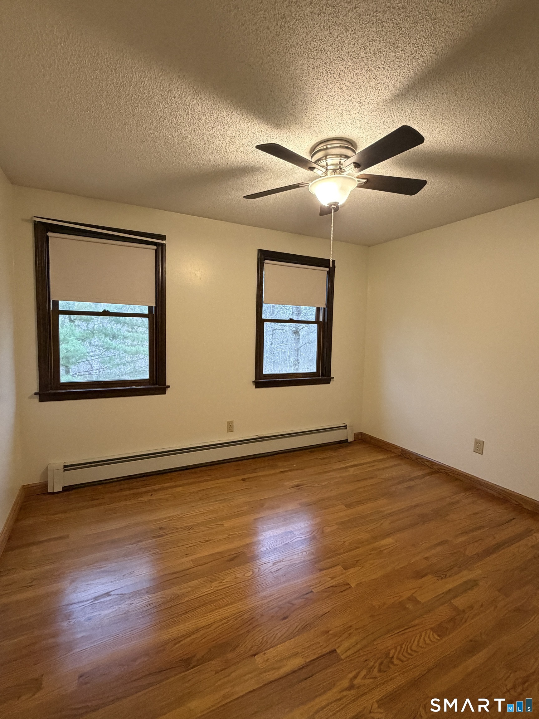 8 Brook Lane, Unit 2 Guilford, CT 06437 - Photo 3 of 12 a view of an empty room with wooden floor and a window
