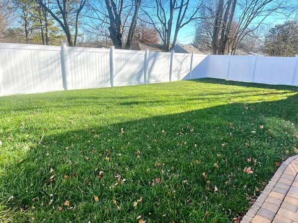 a view of a backyard with wooden fence