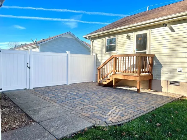 a view of a house with a wooden deck and a yard