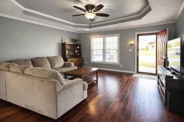 a living room with furniture and a flat screen tv with wooden floor