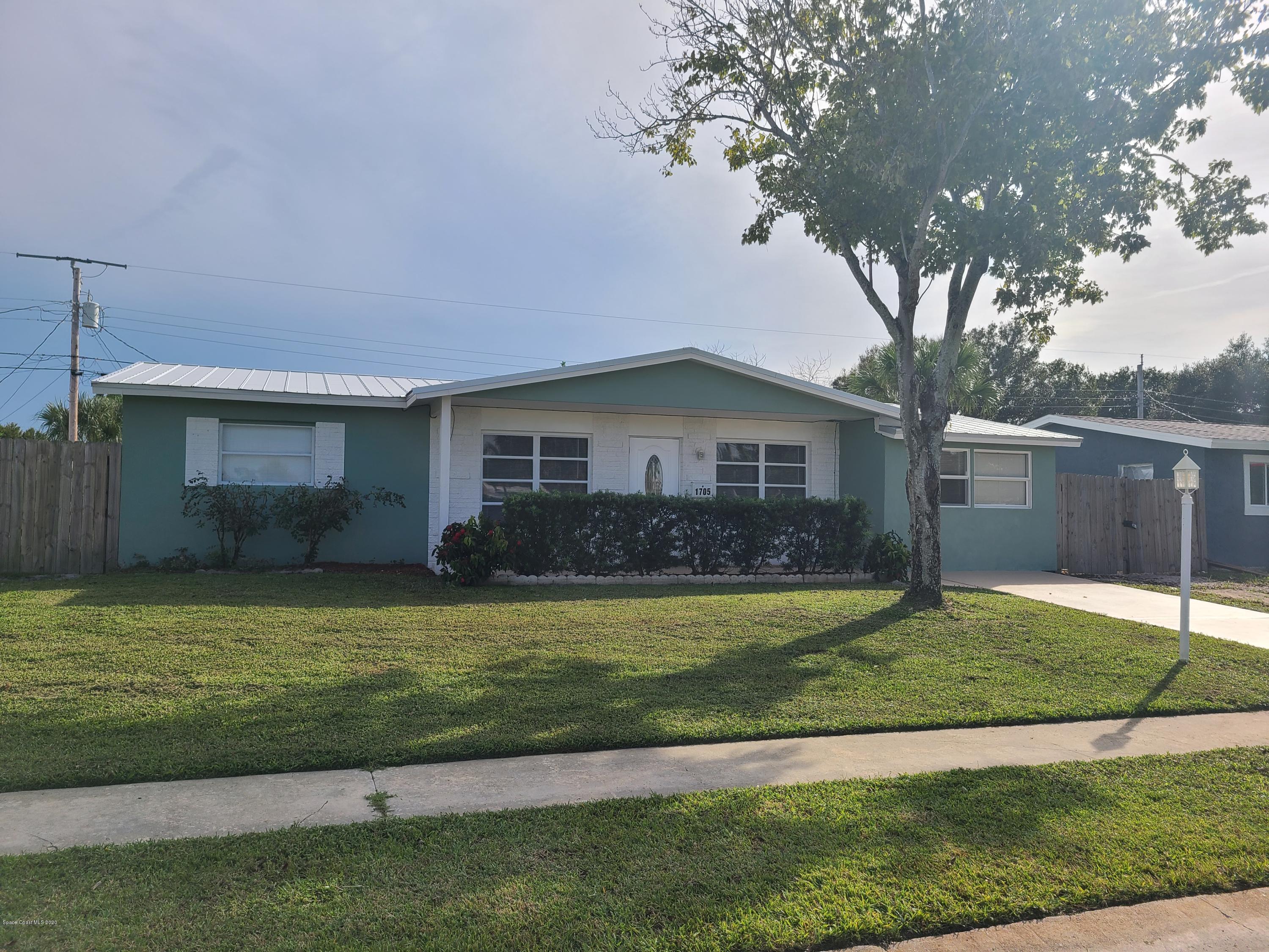 1705 Sarno (access) Road Melbourne, FL 32935 - Photo 1 of 32 a view of a house with a yard and a large tree