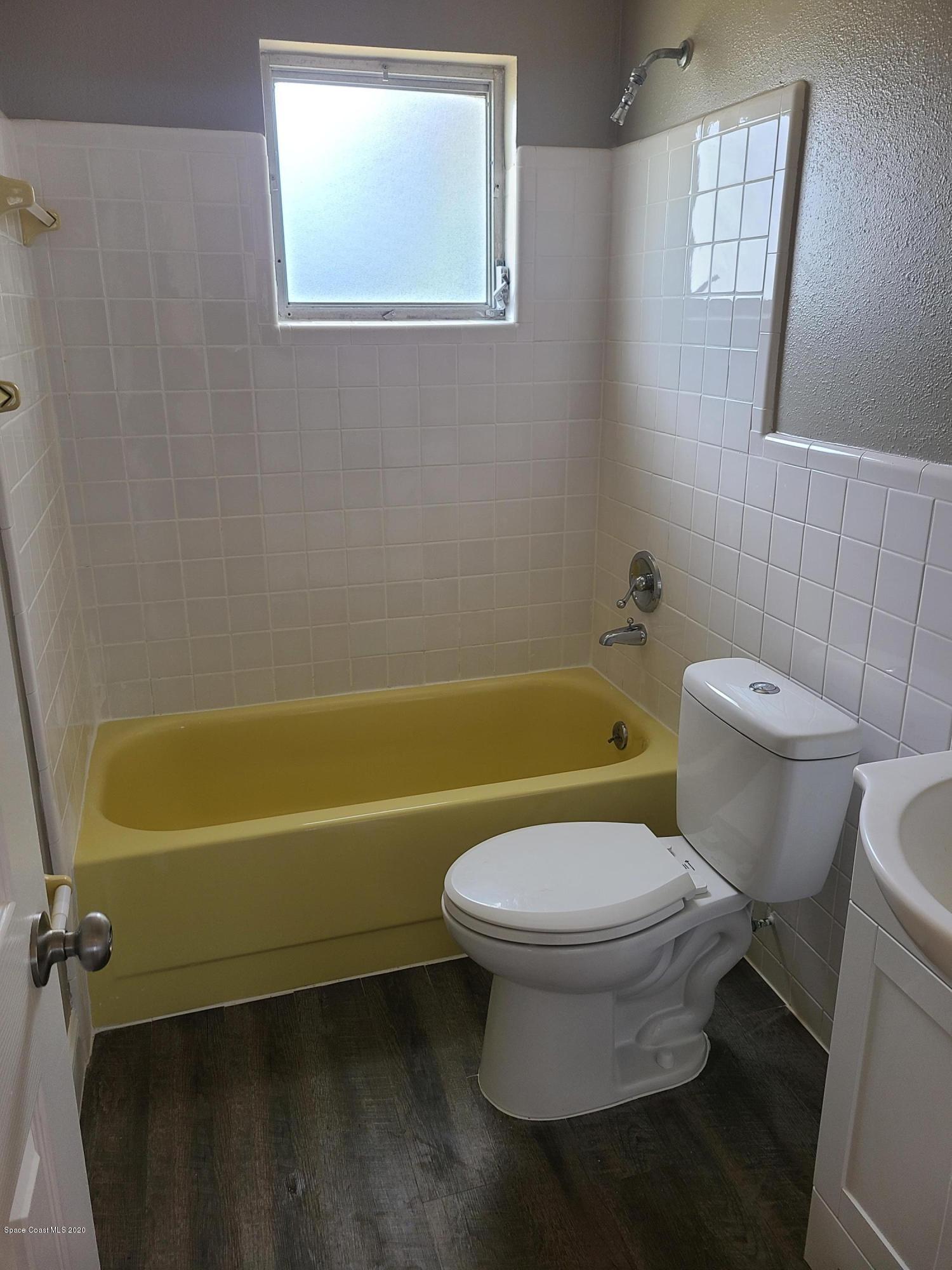 1705 Sarno (access) Road Melbourne, FL 32935 - Photo 22 of 32 a white toilet sitting next to a bath tub and a shower