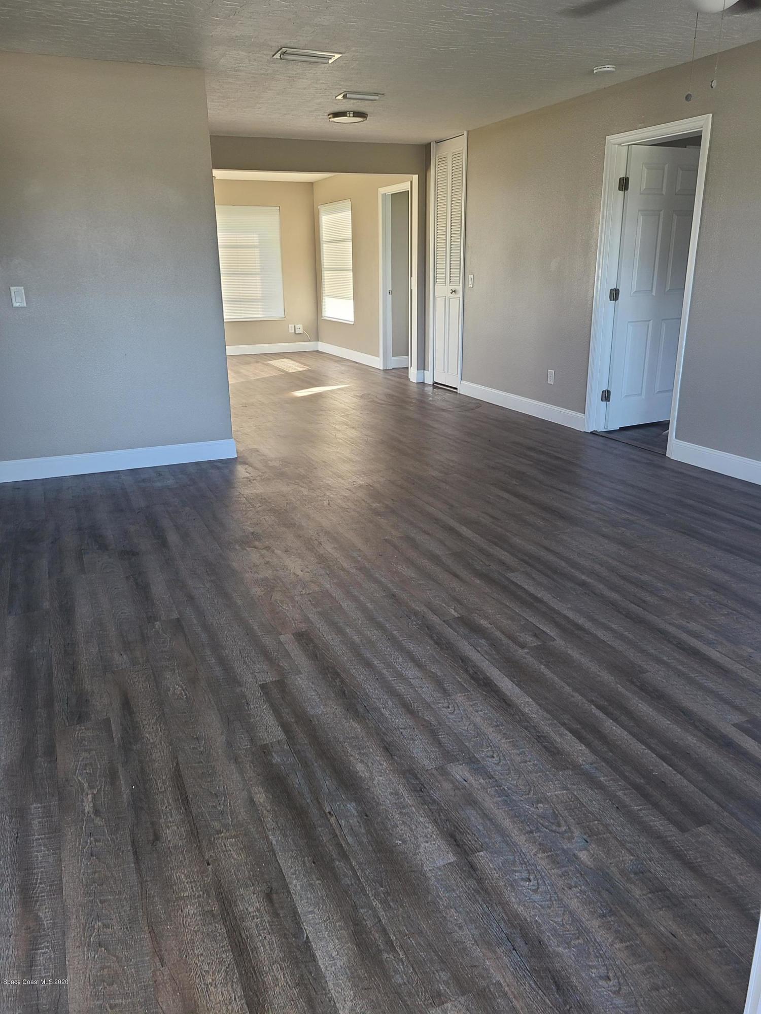 1705 Sarno (access) Road Melbourne, FL 32935 - Photo 5 of 32 a view of an empty room with wooden floor and window
