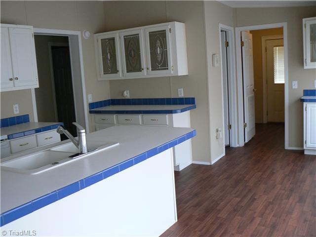 Kitchen. Kitchen is 13  x 16  6", has an island with double sinks, dishwasher & bar. Kitchen sink has pull out faucet. Door to left leads to  short hall with bedroom on each end and full bath between. First door beyond kitchen leads to pantry. Laundry beyond.