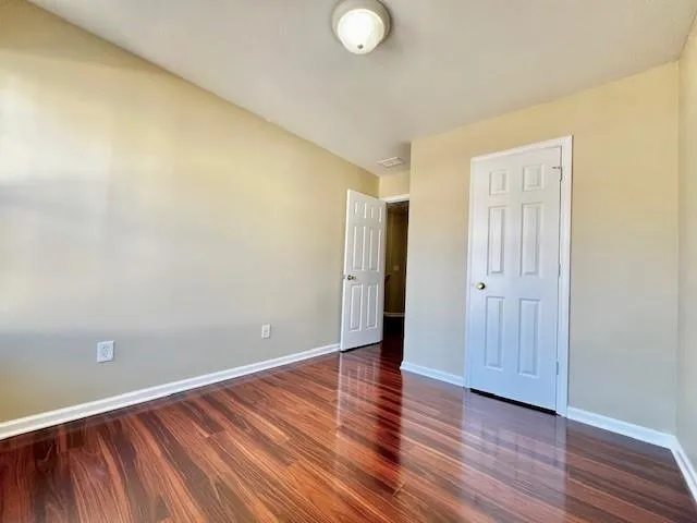 a view of an empty room with wooden floor