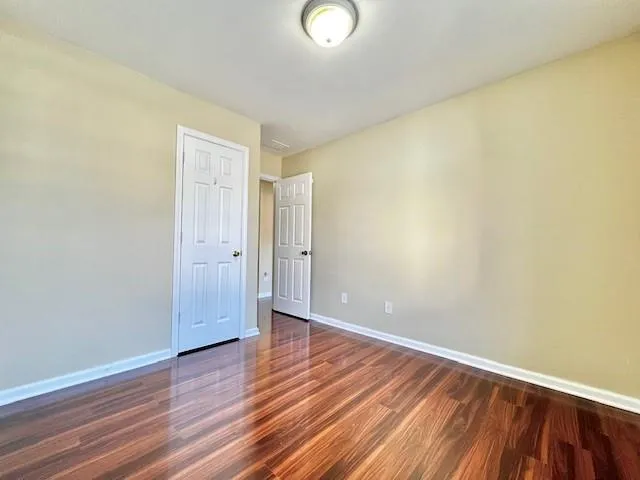 a view of an empty room with wooden floor
