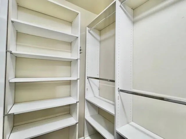 a view of walk in closet with empty racks
