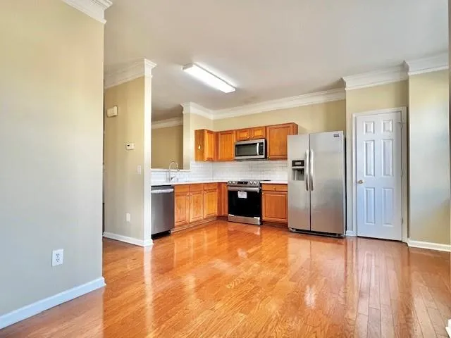 a large kitchen with a center island and stainless steel appliances