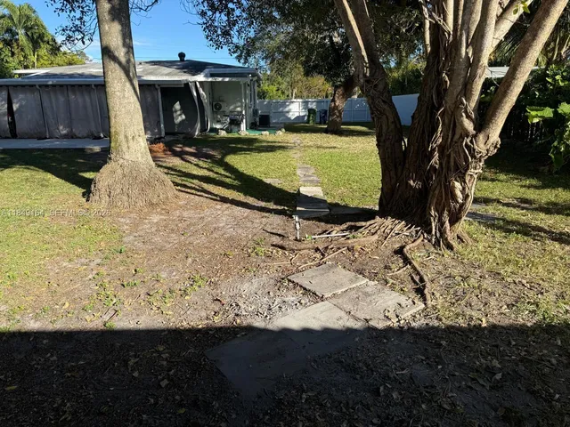 an aerial view of residential houses with outdoor space and trees