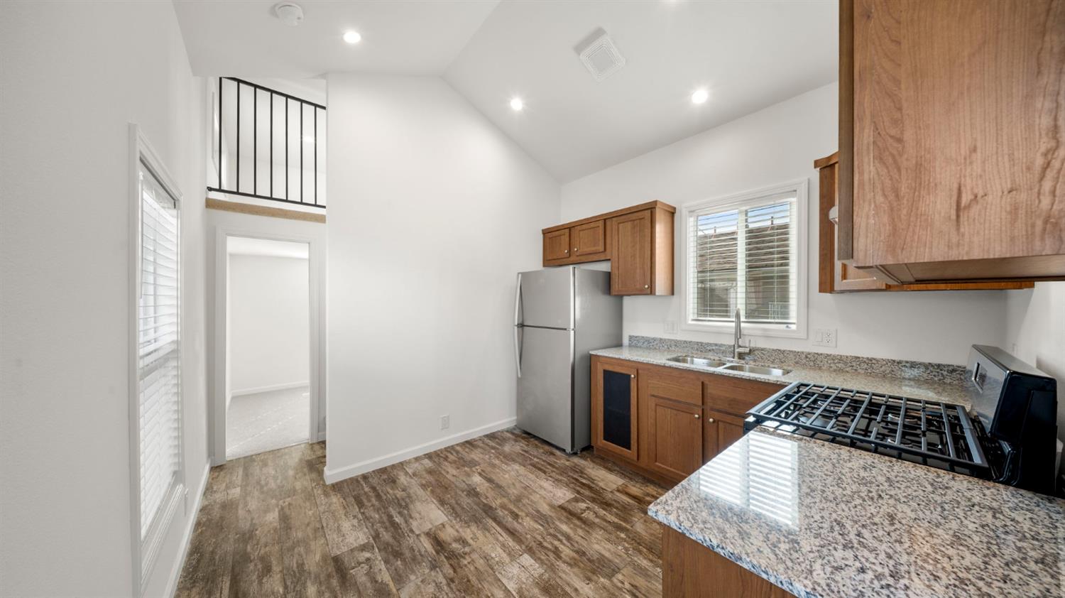 2784 Monterey Road, Unit 43A San Jose, CA 95111 - Photo 4 of 13 a kitchen with granite countertop a stove a refrigerator and wooden cabinets