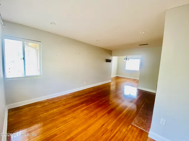 a view of empty room with wooden floor