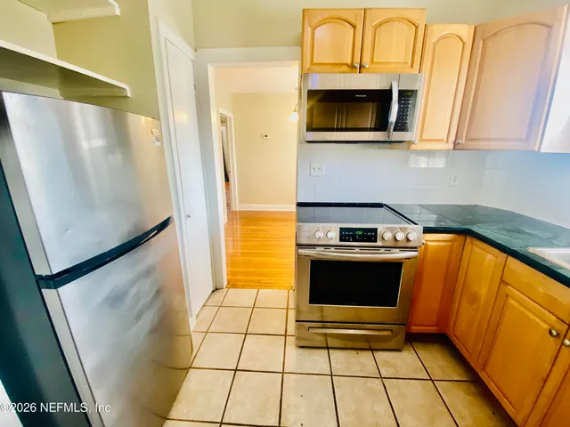 a kitchen with stainless steel appliances a stove a microwave and a refrigerator