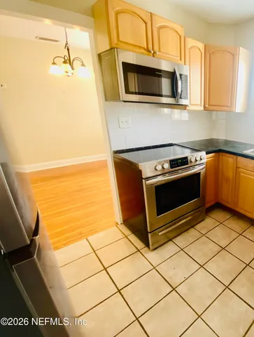 a kitchen with stainless steel appliances a stove a microwave and a sink