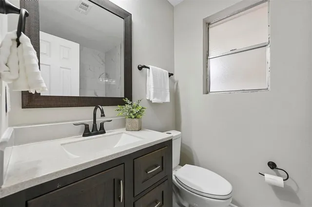 a bathroom with a sink a toilet and mirror
