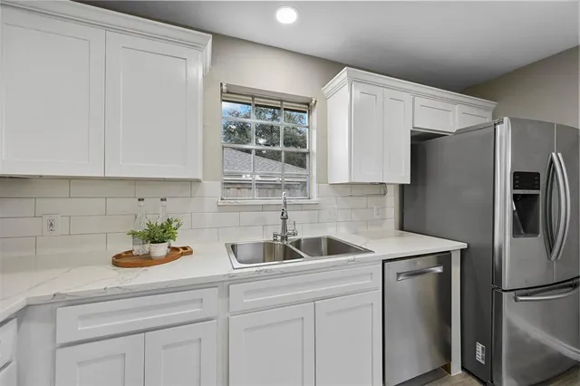 a kitchen with stainless steel appliances white cabinets and a sink