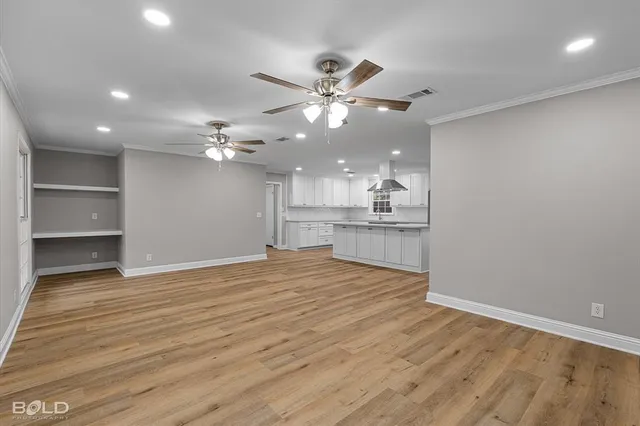 a view of an empty room and kitchen view