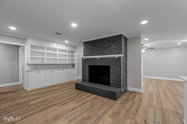 a view of a livingroom with wooden floor and a kitchen