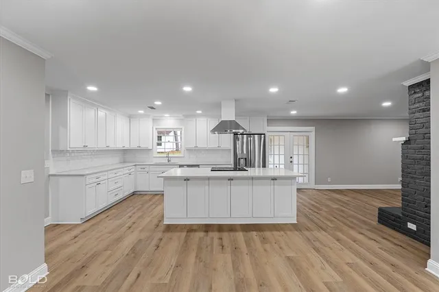 a large kitchen with kitchen island a sink stainless steel appliances and cabinets