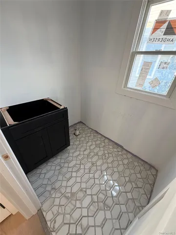 a view of a hallway with wooden floor and a bathroom