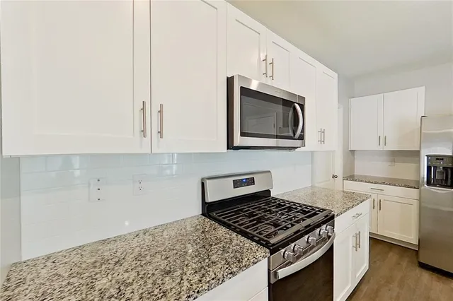a kitchen with stainless steel appliances granite countertop a sink stove and microwave