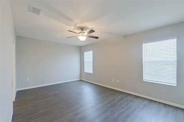 an empty room with wooden floor and window