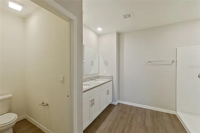 a bathroom with a granite countertop sink a toilet and a mirror