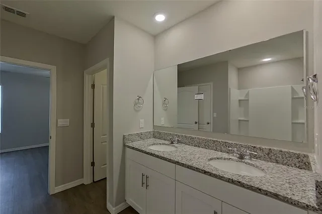 a bathroom with a granite countertop sink and a mirror