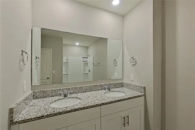 a bathroom with a granite countertop sink and a mirror