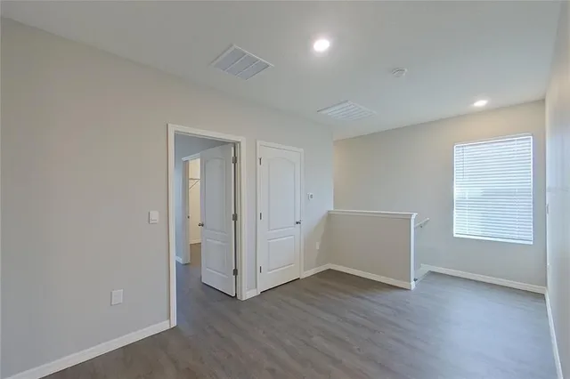 an empty room with wooden floor and window