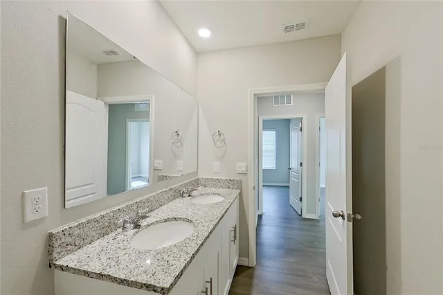 a bathroom with a granite countertop sink and a mirror