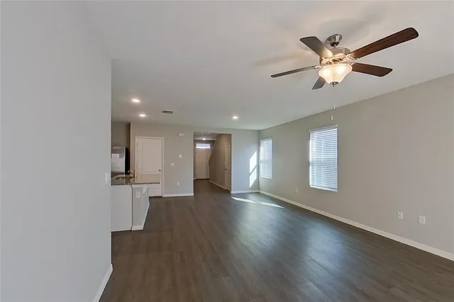 a view of a livingroom with a ceiling fan and wooden floor