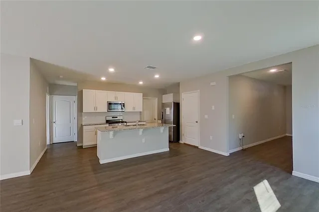 a kitchen with a refrigerator and a stove top oven