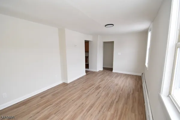 a view of a room with wooden floor and white walls