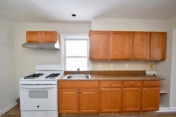a kitchen with stainless steel appliances granite countertop a stove a sink and a white cabinets