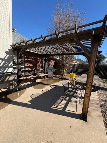 a view of a patio with table and chairs a barbeque grill with wooden fence