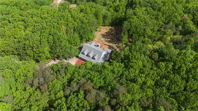 a kitchen with stainless steel appliances granite countertop a stove a sink a microwave a dining table and chairs with wooden floor