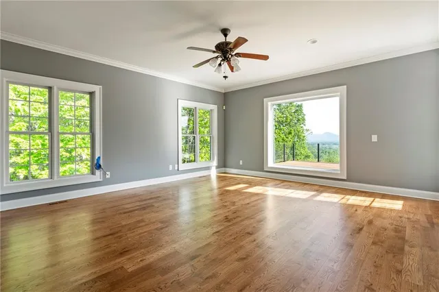 a room with wooden floor pool table and windows