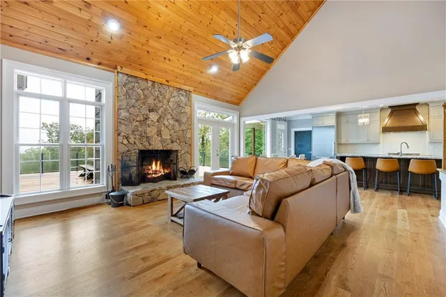 a kitchen with stainless steel appliances granite countertop a kitchen island a stove a table and chairs with wooden floor