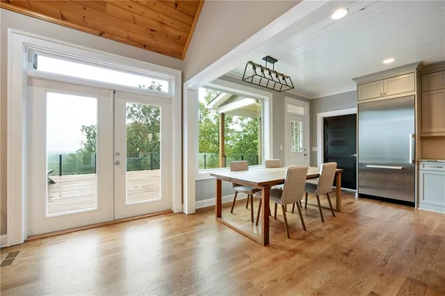 a dining hall with granite countertop a dining table chairs and a wooden floor