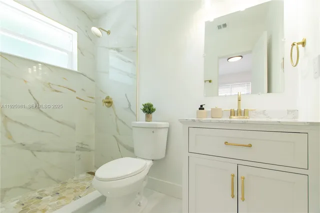 a bathroom with a sink a toilet and shower